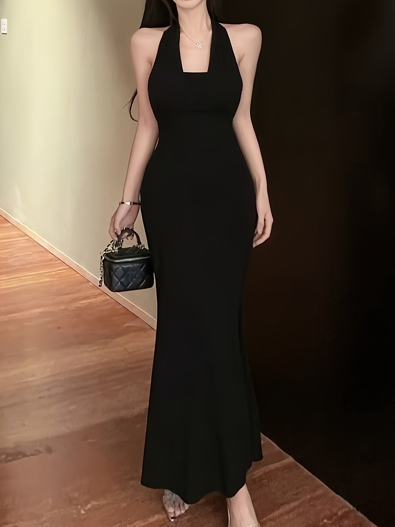 A Black Designer Chain Neck Strap Backless Dress for Women, Featuring a Sexy, Fitted Silhouette with a Mermaid Hem And Built-In Padding, Perfect for Summer.